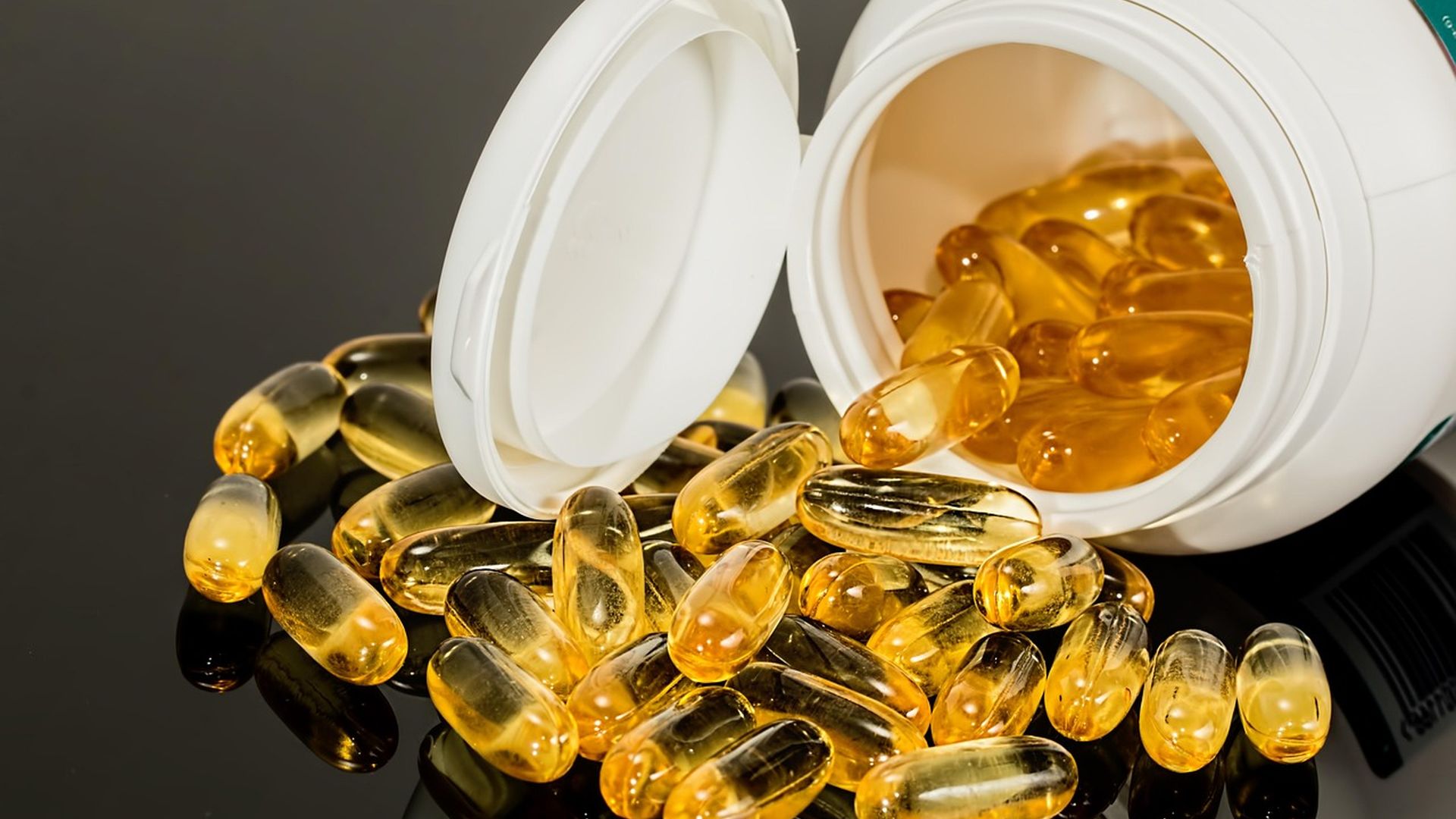 Supplement capsules spilling from a bottle