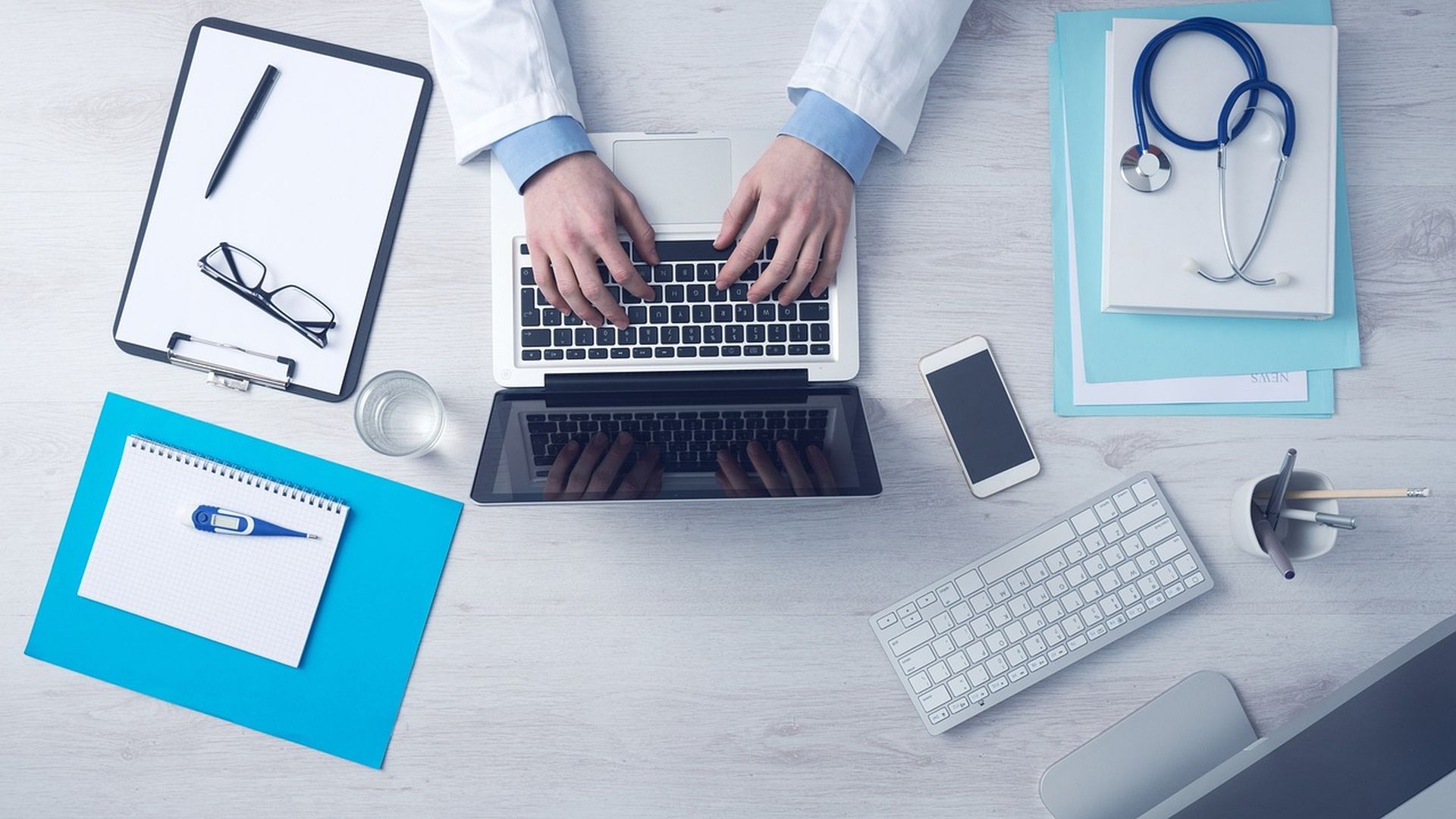Doctor working on a laptop with a stethoscope